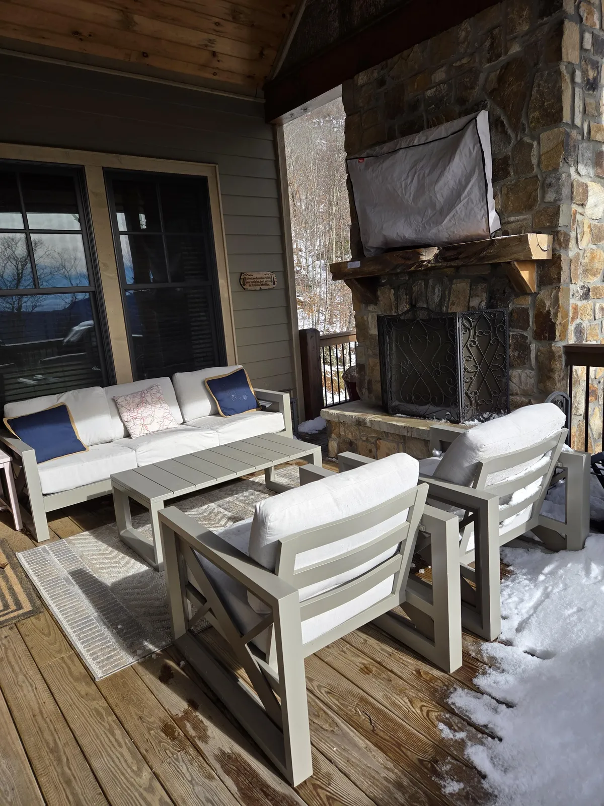 An inviting outdoor stone fireplace and comfortable seating area on a wooden deck, ideal for relaxing after a day's adventure and enjoying the surrounding views.